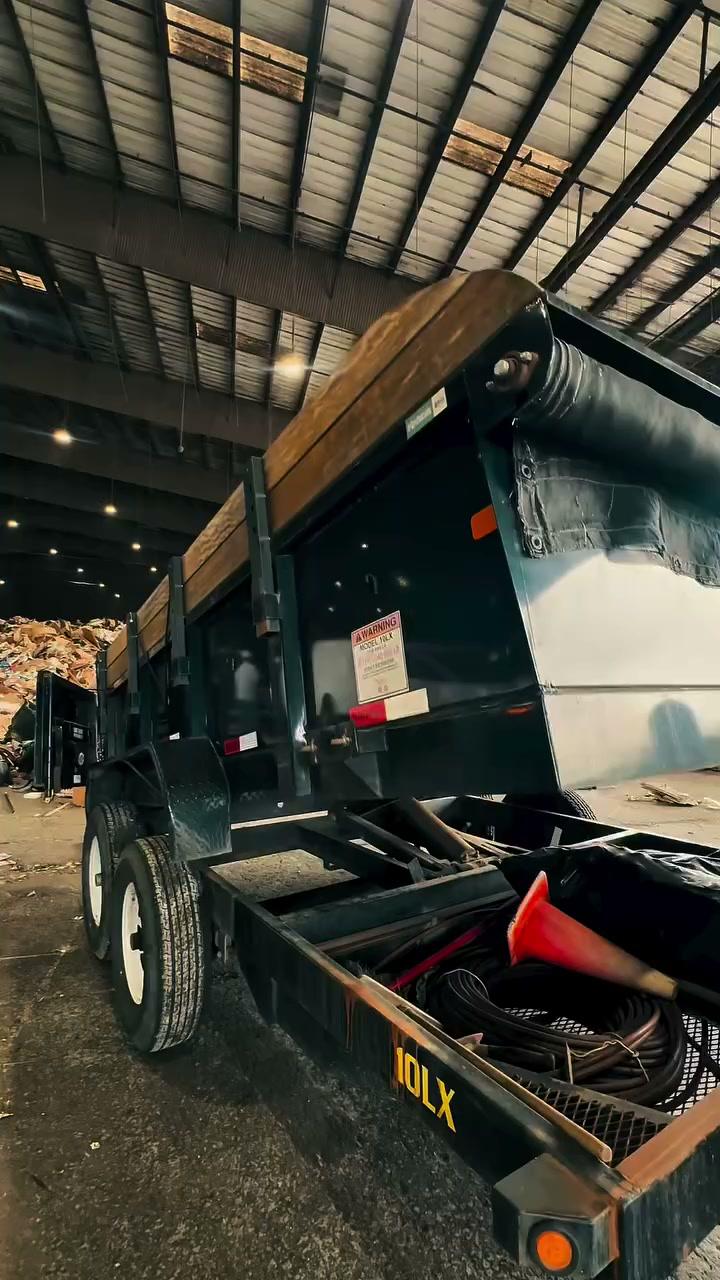The bin tipping its load out onto the floor at a transfer station